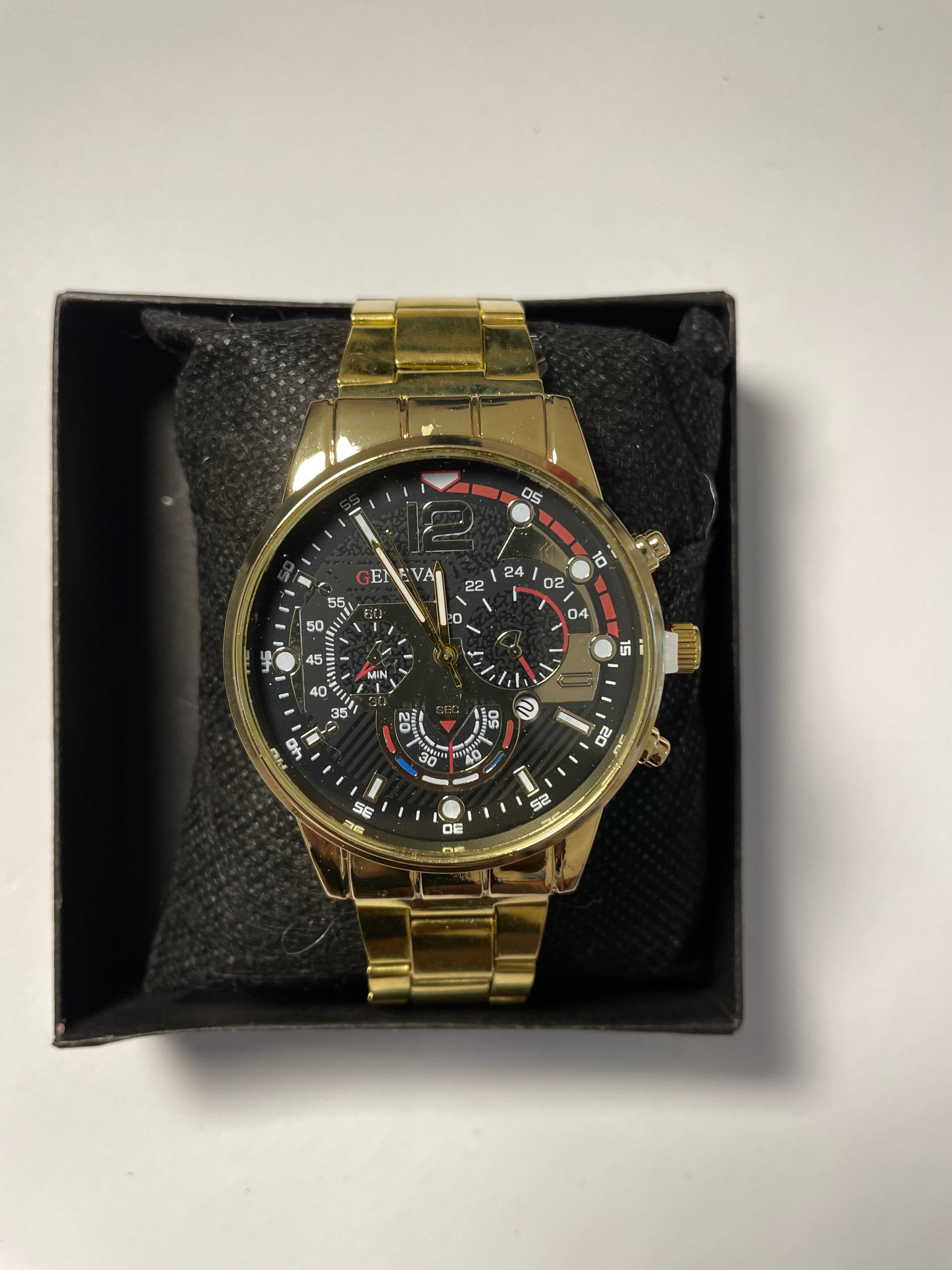 Black and gold watch with red accents